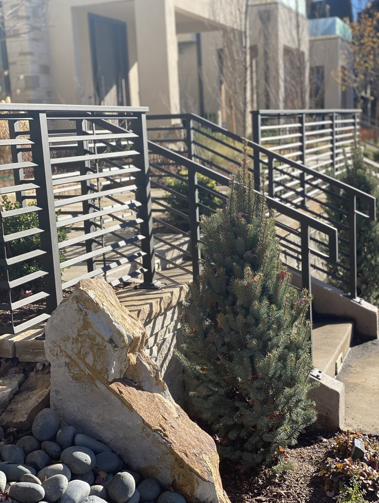 Flagstone steps, steel railing, and boulder feature
